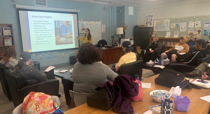 Speaker talking to students while giving a presentation.