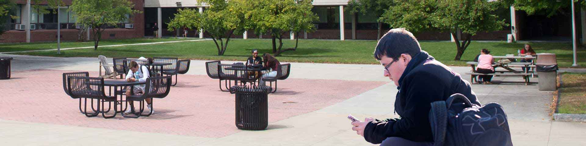 An NECC current student using Navigate on his phone outside.