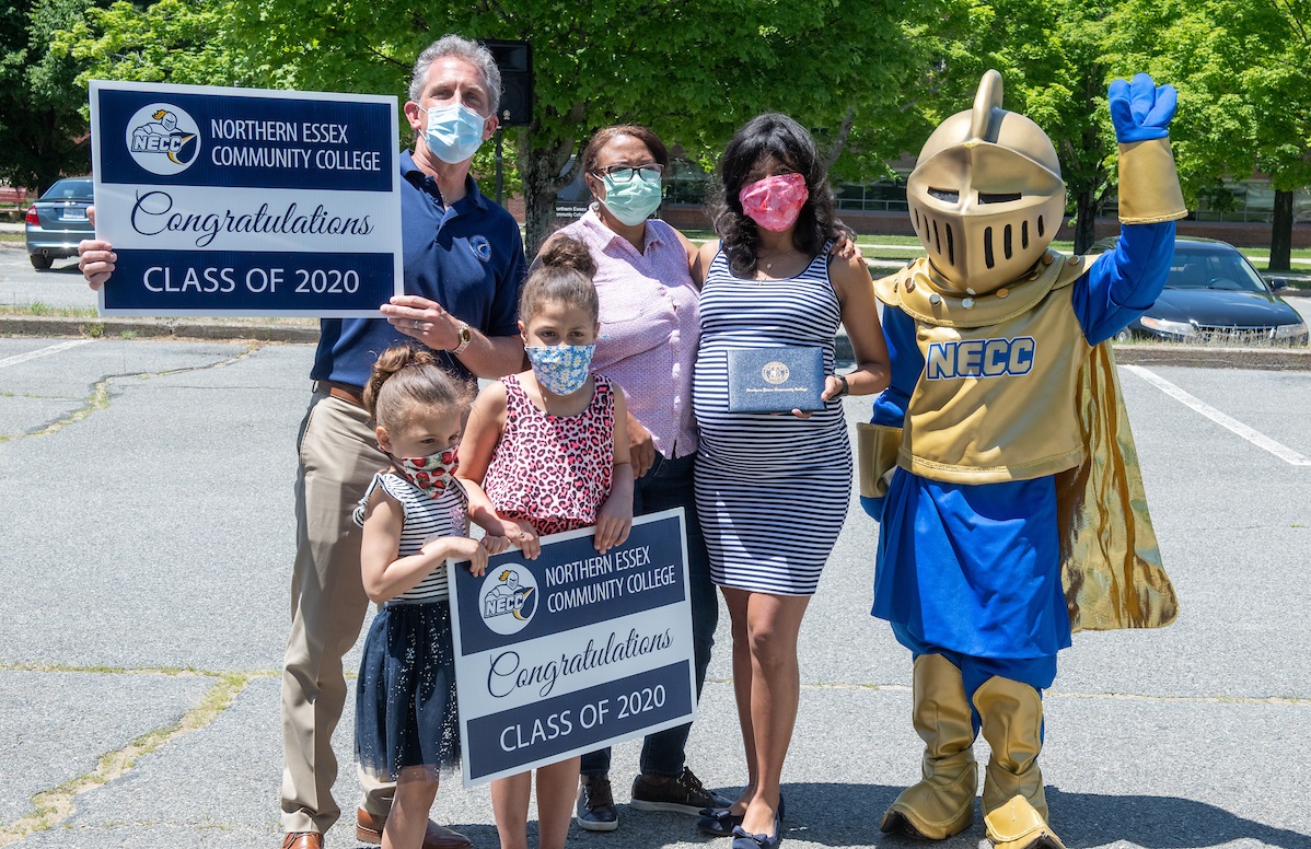 Dr. Lane A. Glenn, President of NECC and the NECC Knight stand with a female graduate and her family.