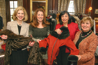 Models for Dino International Furs, Joanne Dee and Mary Tyrrell, both of Andover, Anne Mantsios of Dino International Furs, and Gerri Murphy of North Andover admire a few of the items modeled during the Women of NECC's holiday luncheon and fashion show. 