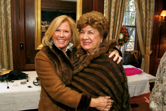 Jeannie Scarpa of Andover and Gloria Kirsch of Methuen strike a pose while modeling furs For Dino International Furs during the Women of NECC's holiday luncheon and fashion show which raises money for scholarships.