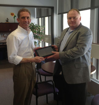 NECC President Lane Glenn receives one of four Dell Latitude Tablets from Shannon Boelter, Account Executive of Dell. They will be awarded to NECC students who win various academic competitions.