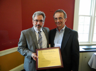 Michael Badolato, of Newton, NH, dean of Academic Technology at North Shore Community College (NSCC) in Danvers, presents the Course of Distinction to Chris Rowse