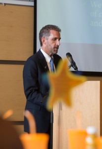 NECC President Lane Glenn sporting a late summer beard addresses standing room only crowd at fall convocation.