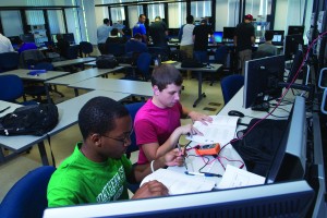 Engineering students analyzing an electronic circut 