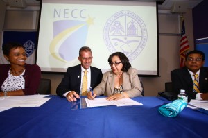 Lane Glenn, NECC president, and Clara Benedicto, USAD director of cooperation and international relations, sign agreement, watched by Noemi Custodia-Lora, NECC (left in photo) and Julio Sepulveda, USAD (right in photo).