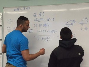 Methuen resident and NECC student Caros Rrivera, who is a student assistant in the Student Success Center, reviews a math problem with a student.
