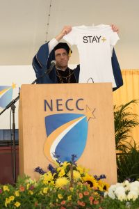 NECC President Lane Glenn exhibits a Stay+ tshirt which is the creation of graduate CJay DiPrima.