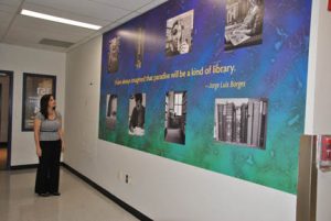 NECC Lawrence Librarian Jennifer Fielding looks at "The Library" mural that was installed outside the information literacy lab.