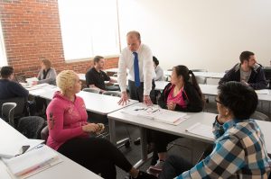 Students and professor have conversation in classroom