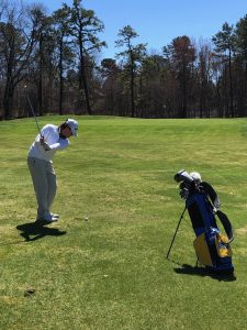 Brandon Mullarekey taking a swing on the golf course.