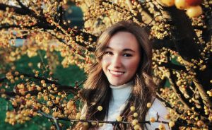 A portrait of Courtney Morin outside by a tree.