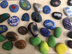 a batch of colorfully painted kindness rocks.