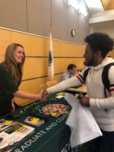 NECC student Joann Mejia shakes hands with representative from Fitchburg State University