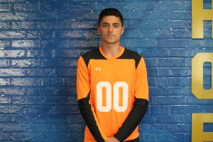 soccer player stands in front of a wall