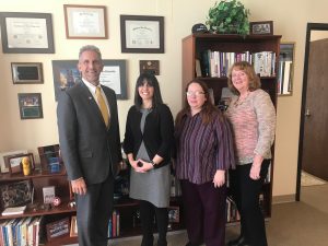 President Lane Glenn standing in his office with the Employee Recognition Recipients