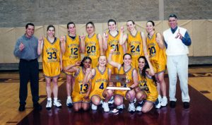 The members of the 2000-01 women's basketball team and their coaches pose for a celebratory photo. 