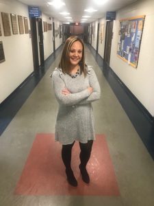 Aracelis Alvarado standing in a classroom building hallway.