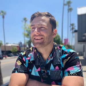 Matt Incontri is wearing a brightly printed shirt and smiling.