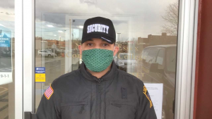 security officer Angela Mejia wears a mask made by NECC employees