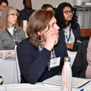 Jonas Ruzek sitting at a desk at a journalism conference.