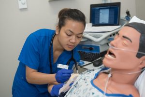 LPN Student practices on training mannequin.