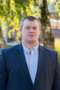 portrait of young man wearing blue sport coat.