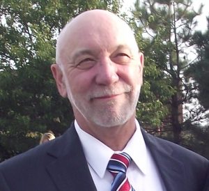 bald man wearing suit jacket and tie