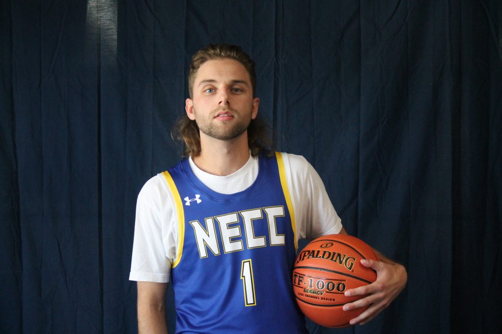 matthew holding basketball looking at camera in NECC jersey