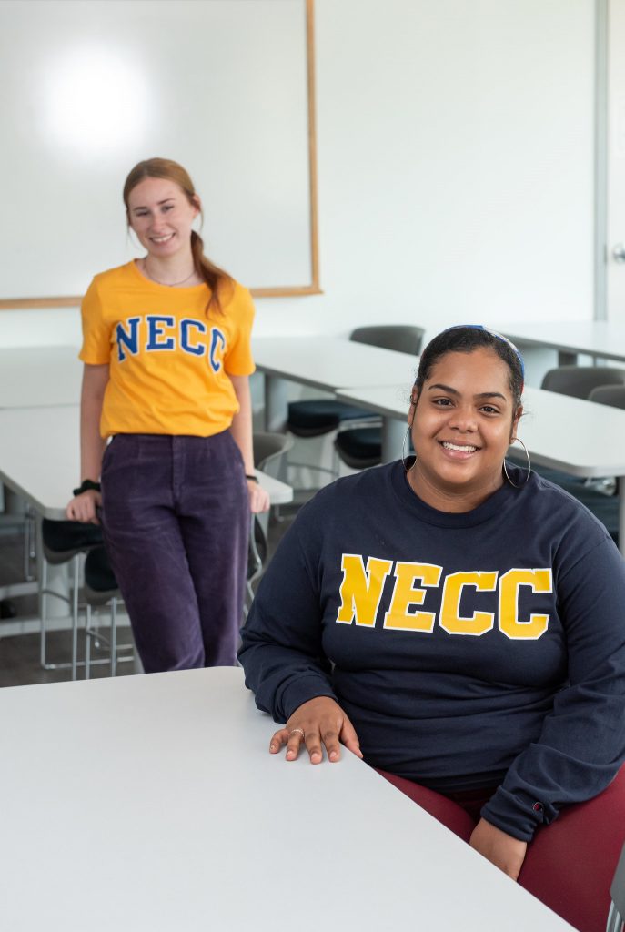 two students in NECC sweatshirts in a classroom