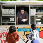 Food truck operator leans out of the window to take an order