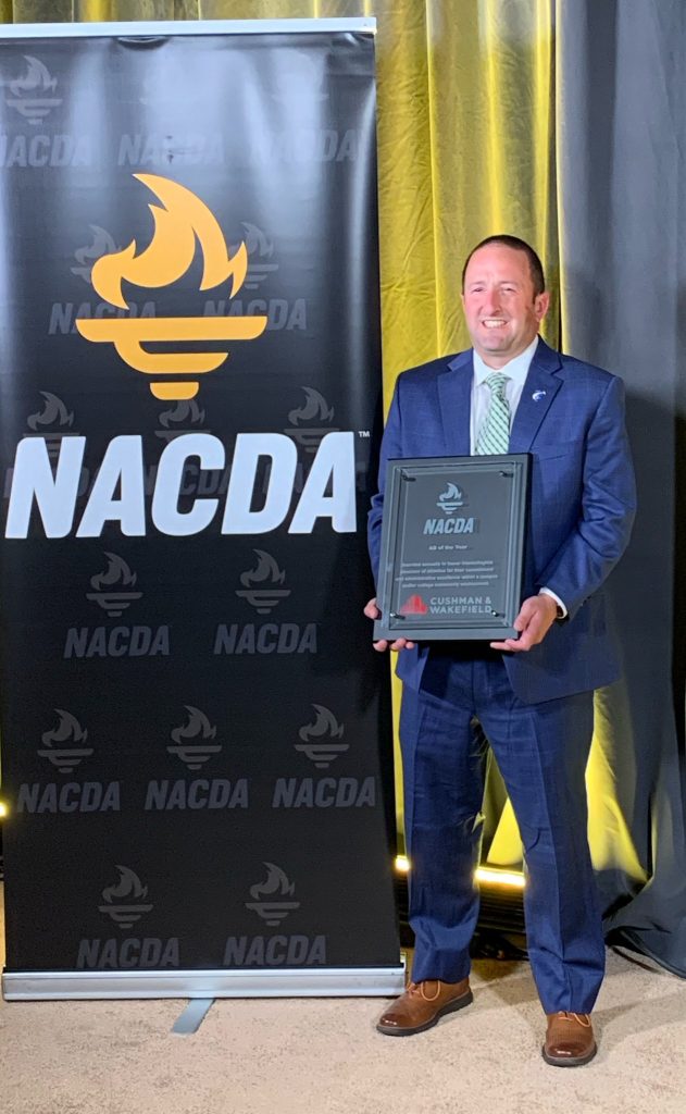 dan holding award in front of NACDA backdrop