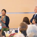 President Glenn listens to professor standing with microphone