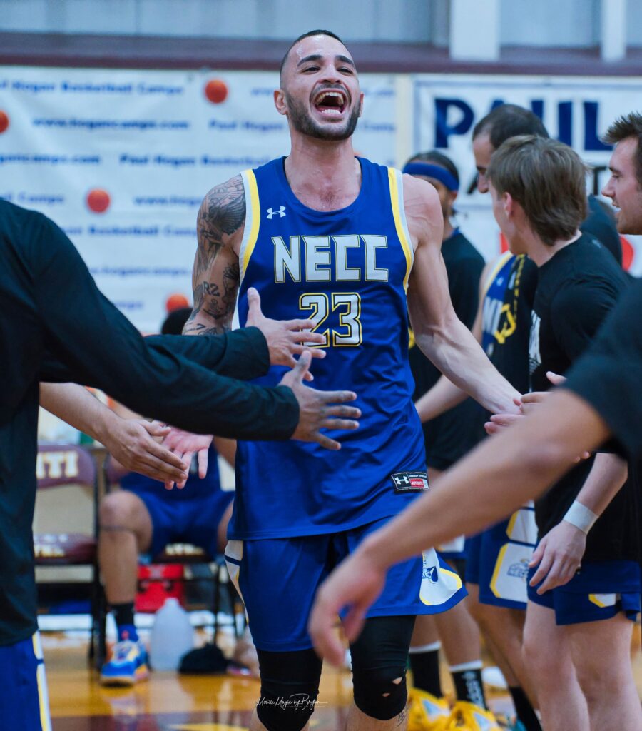 basketball player wearing the number 23 runs in between teammates with outstreteched arms