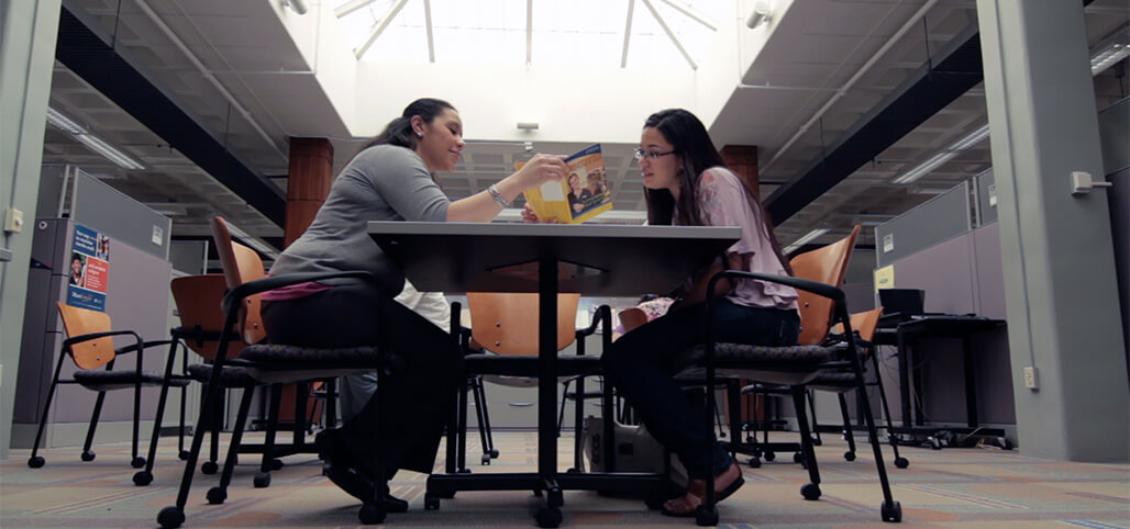 Two Students browsing through a brochure