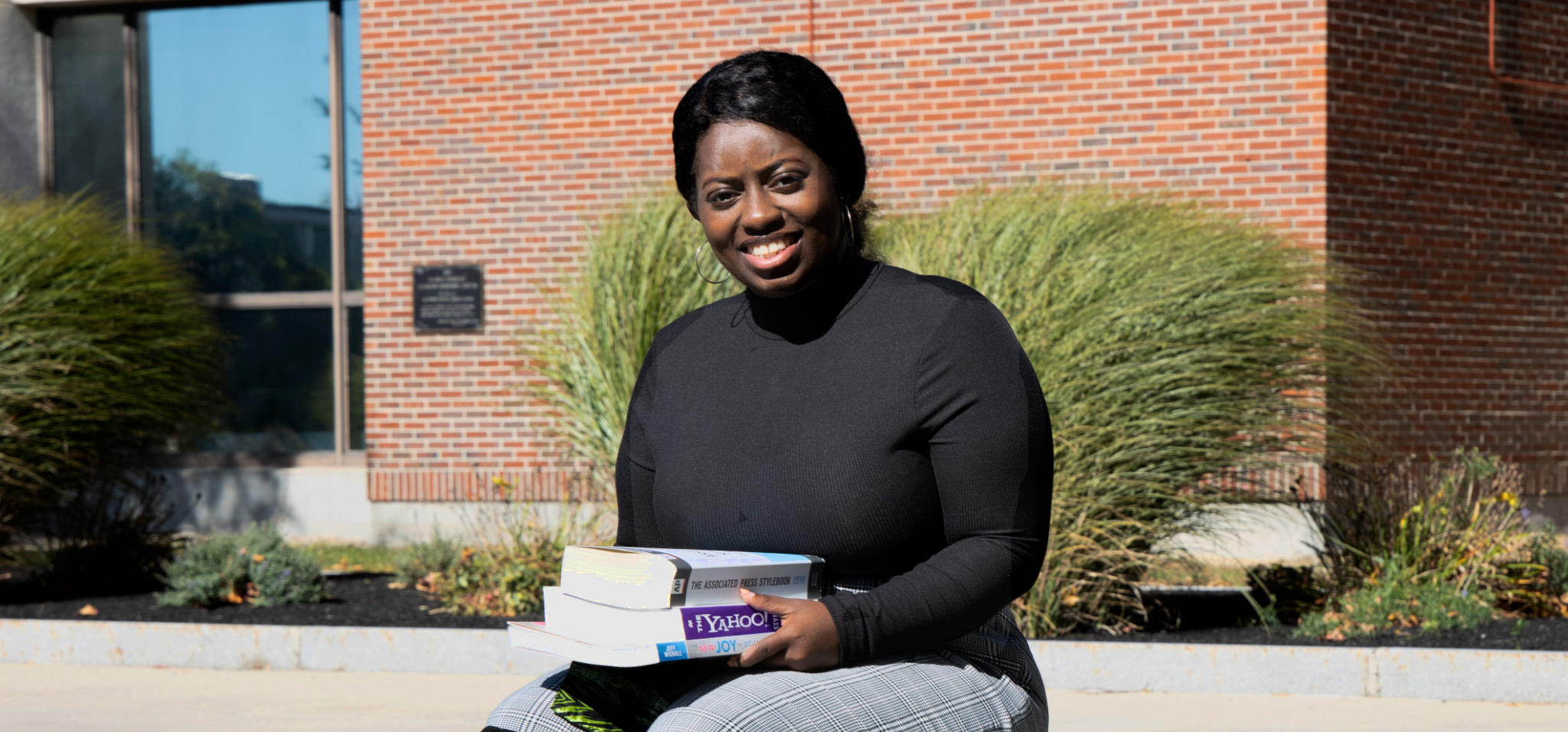 Young woman holding textbooks on NECC campus