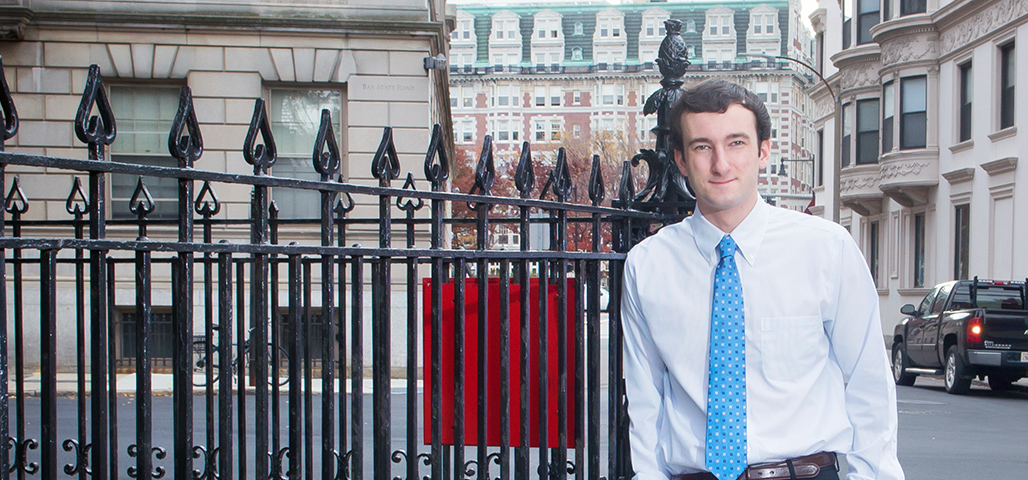 A Technology and Business student in formal business attire, stands outside in the city.