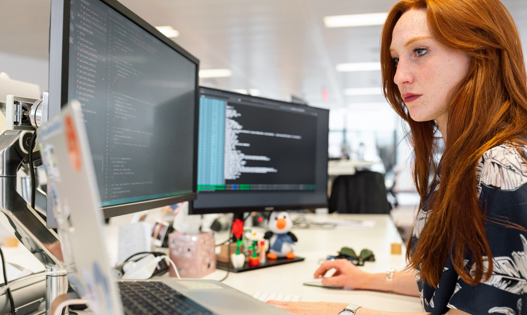 A woman sitting at a desk coding.