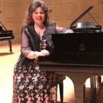 Christina Dietrich, seated at a grand piano in the music room.