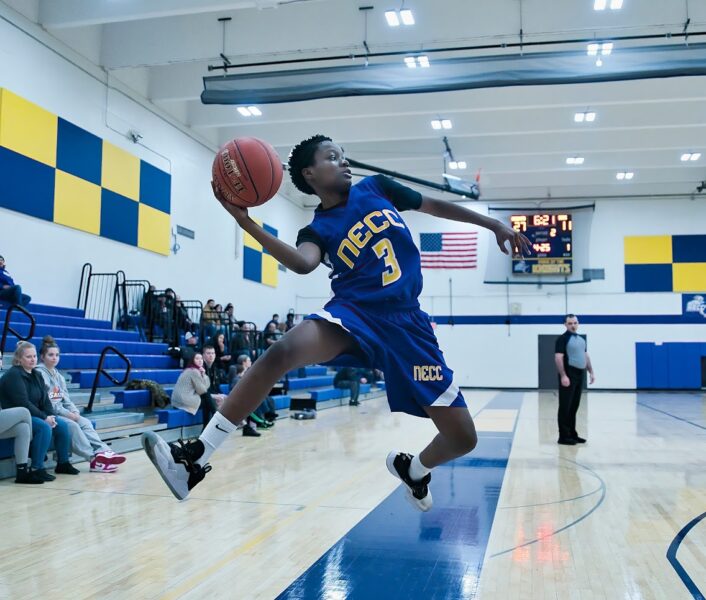 An NECC basketball player dunking the ball