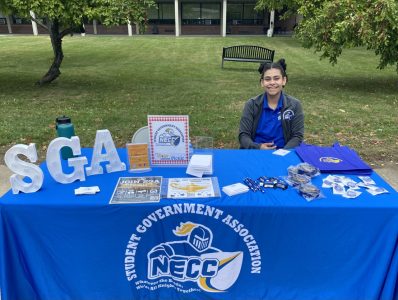 A photo of a woman sitting at a table representing the SGA