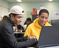 Two students work together on a computer