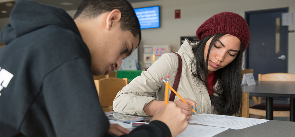 Two Liberal Arts: Writing degree students at a table working on papers.