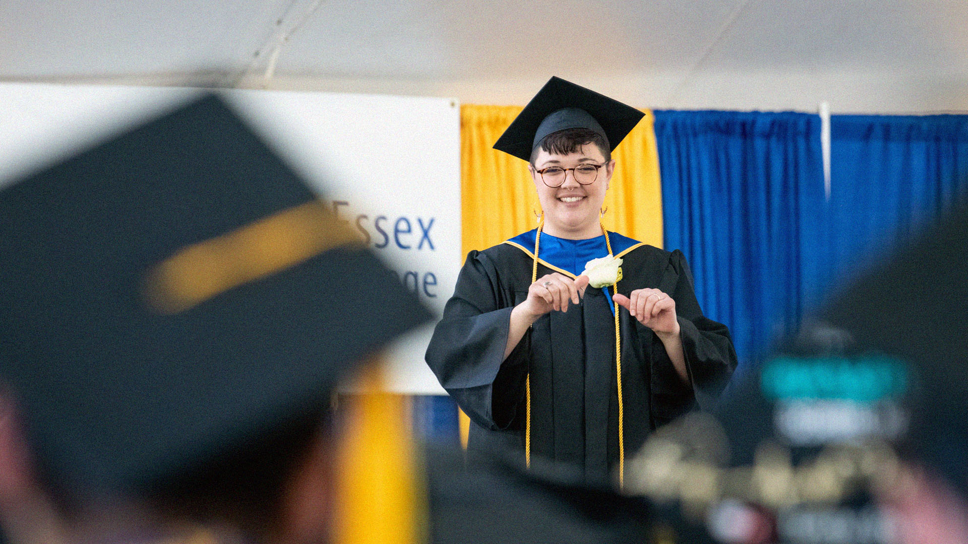 A photo of students at the NECC Commencement watching the student speaker speak ASL