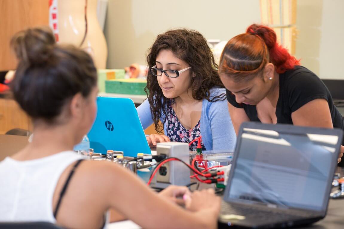 Three female students in computer lab.